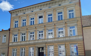 Zdjęcie przedstawia budynek, w którym znajduje się lokal mieszkalny na sprzedaż.